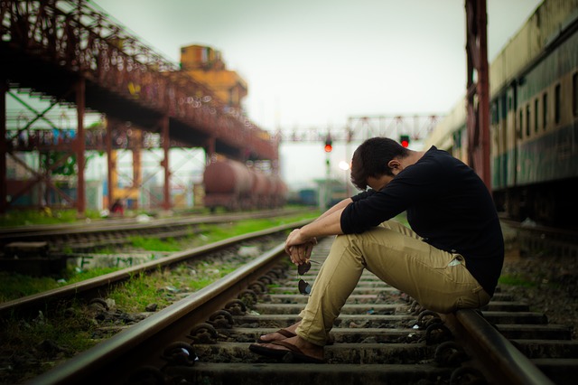 Man sitting on traintracks